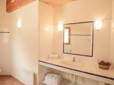 a white bathroom with a sink and a mirror at Villa Bellegarde in Saignon