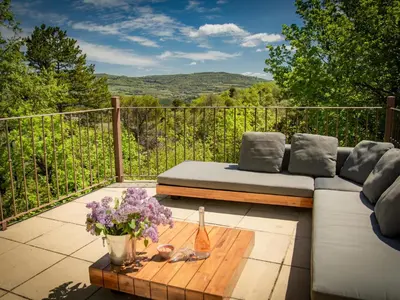 a patio with a couch and flowers on a table at Villa Bellegarde in Saignon