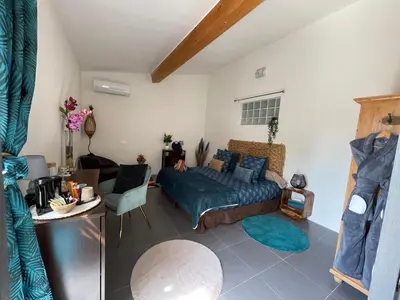 a bedroom with a bed and a living room at Mas de la Butte Blanche in Orgon
