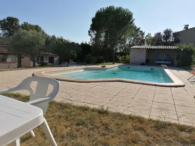 a swimming pool in a yard with a white chair at Maison au calme entre vignes et Luberon in La Motte-dʼAigues