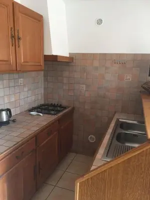 a kitchen with a stove and a sink in it at Au pied du Massif des Costes in Pélissanne