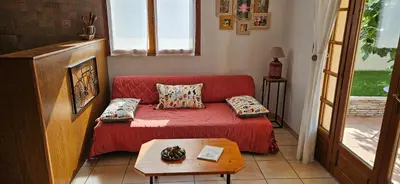 a living room with a red couch and a table at Au pied du Massif des Costes in Pélissanne
