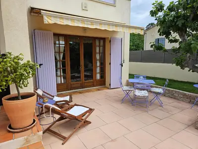 a patio with chairs and a table and a table at Au pied du Massif des Costes in Pélissanne