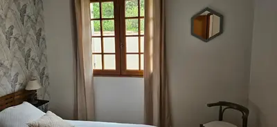 a bedroom with a window and a bed and a chair at Au pied du Massif des Costes in Pélissanne