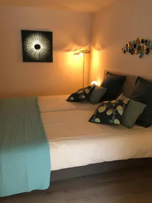 a bed with white sheets and pillows in a room at Le Loft sur les quais in LʼIsle-sur-la-Sorgue