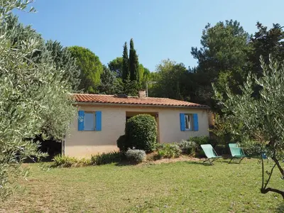 a house with two chairs in a yard at Cottage in Luberon near Apt Market in Apt