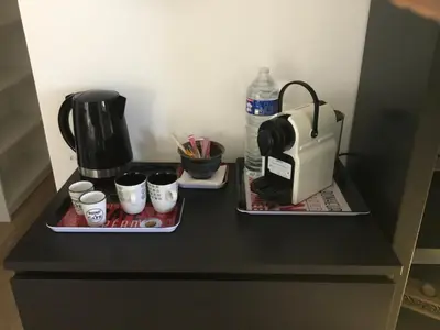 a counter with two trays with cups and a coffee maker at Petit cocon dans le Luberon in Lauris