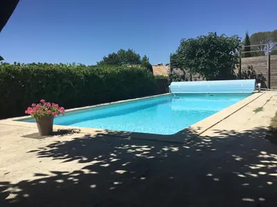 a swimming pool with blue water in a yard at Petit cocon dans le Luberon in Lauris