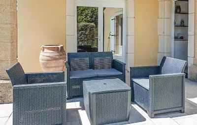 a group of wicker chairs and tables on a patio at Cozy Home In Cabannes With Wifi in Cabannes