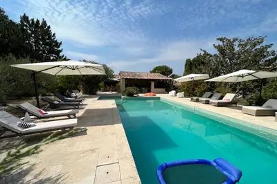 a swimming pool with lounge chairs and umbrellas at Villa de 300 m au coeur du Luberon au calme sans in Maubec