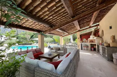 a patio with a couch and a table and a pool at Gite Studio indépendant au cœur du Luberon in Maubec