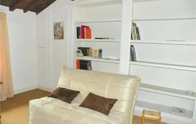 a living room with a leather couch and bookshelves at Nice Home In St Didier With Kitchen in Saint-Didier