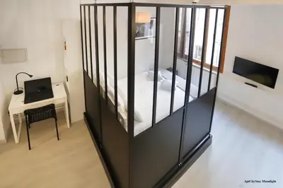 a room with a crib with a bed and a desk at AptCityStay in Apt