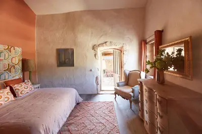 a bedroom with a bed and a chair and a window at Le Mas Vermentino, La Bastide de Marie, Villa avec services in Ménerbes