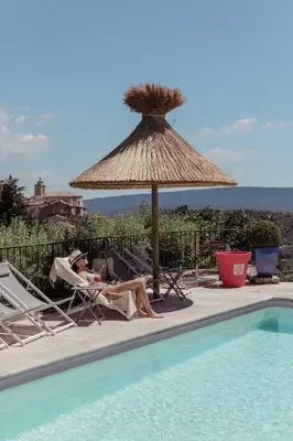 a person is holding a glass of wine at Mas des Romarins, The Originals Relais in Gordes
