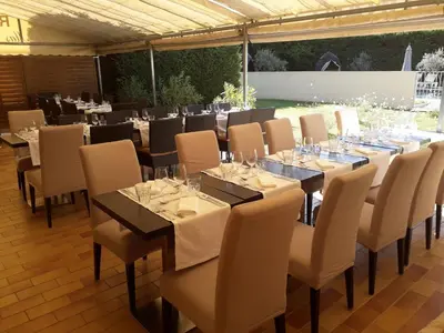 a set of tables and chairs with wine glasses at Le Mas Du Colombier in Cadenet