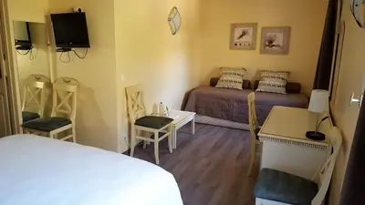 a bedroom with a bed and a table and chairs at Le Mas Du Colombier in Cadenet