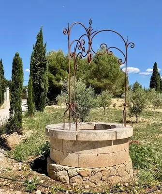 a fountain in the middle of a field with trees at La Soleillade Aixoise in Aix-en-Provence