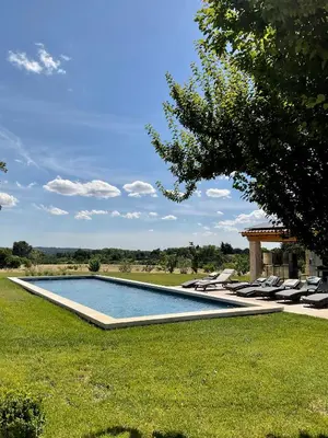 a swimming pool in the middle of a lawn with lounge chairs at La Soleillade Aixoise in Aix-en-Provence