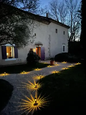 a house with lights in front of a yard at Mas de la Sacristière in Jonquerettes
