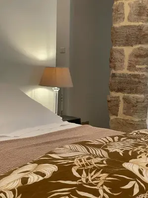 a bedroom with a bed and a stone wall at Mas de la Sacristière in Jonquerettes