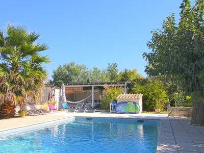 a swimming pool with a slide in a yard at Les Platanes in LʼIsle-sur-la-Sorgue
