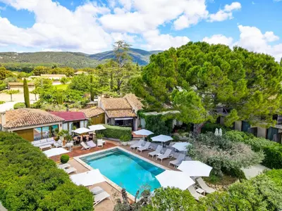 an aerial view of a house with a swimming pool and chairs at Hotel Bastide & SPA - Villa de Lourmarin in Lourmarin