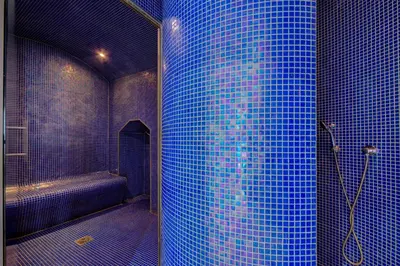 a blue tiled bathroom with a shower and a tub at Hotel Bastide & SPA - Villa de Lourmarin in Lourmarin