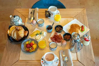 a table with breakfast foods and drinks on it at Hotel Bastide & SPA - Villa de Lourmarin in Lourmarin