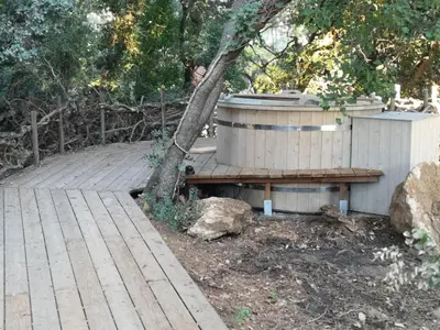 a hot tub sitting next to a tree on a deck at Sortilège in Lambesc