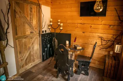 a room with a wooden wall with a table and a door at Sortilège in Lambesc