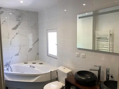a bathroom with a tub and a toilet and a sink at Villa du defens in Saint-Martin-de-Castillon