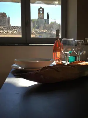 a table with a bottle of wine and two glasses at AJOUCADOU le perchoir in Lourmarin