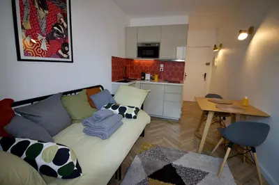 a living room with a couch and a small kitchen at Le Petit Marius in Aix-en-Provence