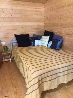 a bedroom with a large bed in a wooden wall at Charmant chalet à Cornillon-Confoux avec piscine partagée in Cornillon-Confoux