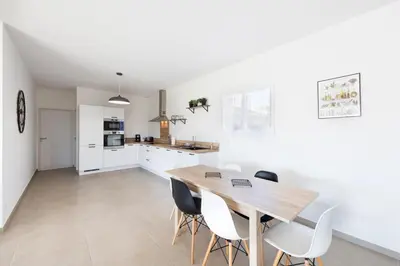 a kitchen and dining room with a wooden table and chairs at Villa Piscine Chauffée & climatisation, 5min du village in Saint-Saturnin-les-Apt