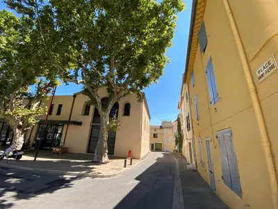 an empty street next to a yellow building with a tree at Villa Noa Pertuis in Pertuis