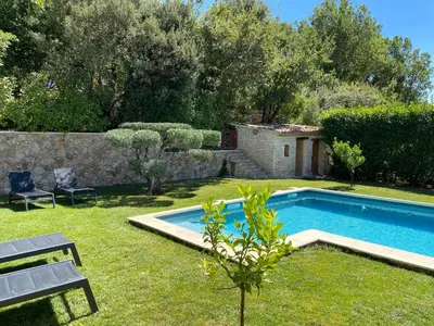 a swimming pool in a yard with a table and a bench at Villa Noa Pertuis in Pertuis