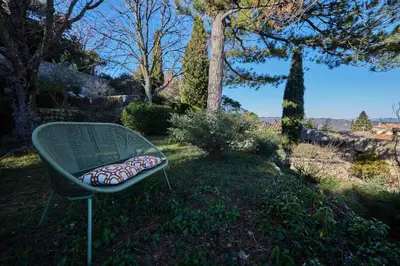 a green bench with a pillow on it in the grass at Le Clos des Merveilles in Rognes