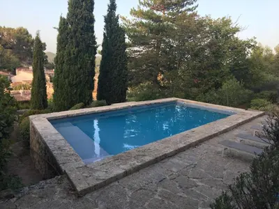 a swimming pool in a garden with trees at Le Clos des Merveilles in Rognes