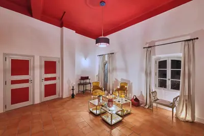 a living room with a red ceiling and chairs and tables at Le Clos des Merveilles in Rognes