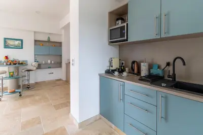 a kitchen with blue cabinets and a counter top at Domaine des Eucalyptus in Mollégès