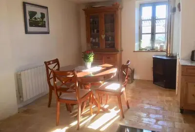 a dining room with a wooden table and chairs at Gîte Coquelicots in Montsalier