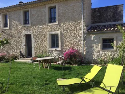a house with chairs and a table in the yard at Gîte Coquelicots in Montsalier