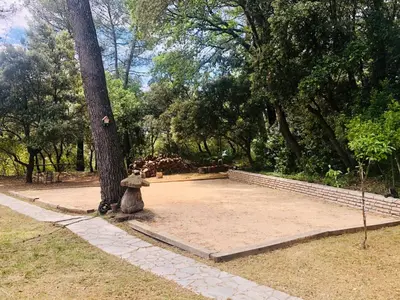 a statue of a dog sitting next to a tree at Maisonnette dans le Luberon - Bois Romay in La Bastide-des-Jourdans