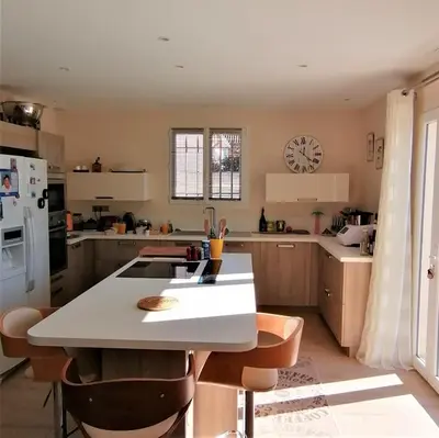 a kitchen with a table and a white counter top at JULIANA in Eyragues