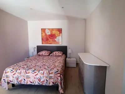 a bedroom with a bed and a painting on the wall at JULIANA in Eyragues