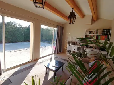 a living room with a large window and a plant at JULIANA in Eyragues