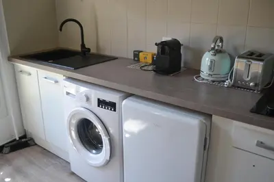 a kitchen with a washing machine and a counter at Appartement Proche Quai Rouget in LʼIsle-sur-la-Sorgue