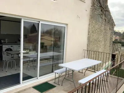 a balcony with a white table and chairs at Clos du Cardinal in LʼIsle-sur-la-Sorgue